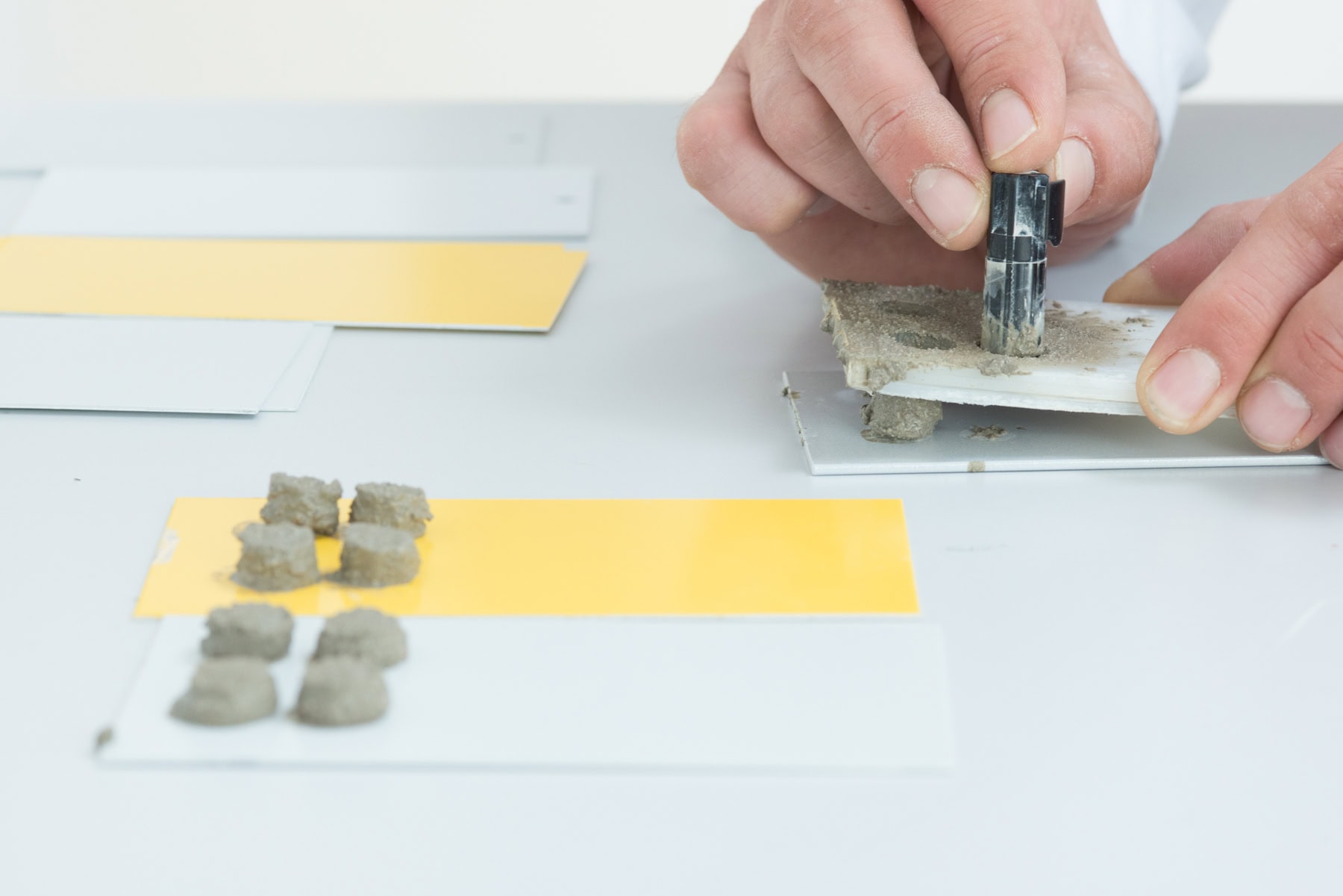 Mörteltest mit Mörtelproben auf beschichteten Prüfblechen