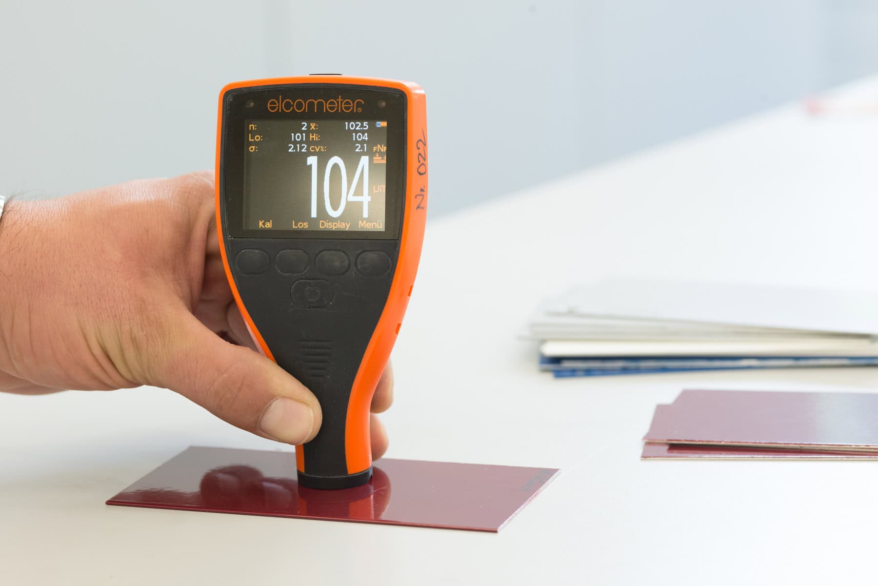 Measuring coating thickness with a handheld measuring device on a test panel
