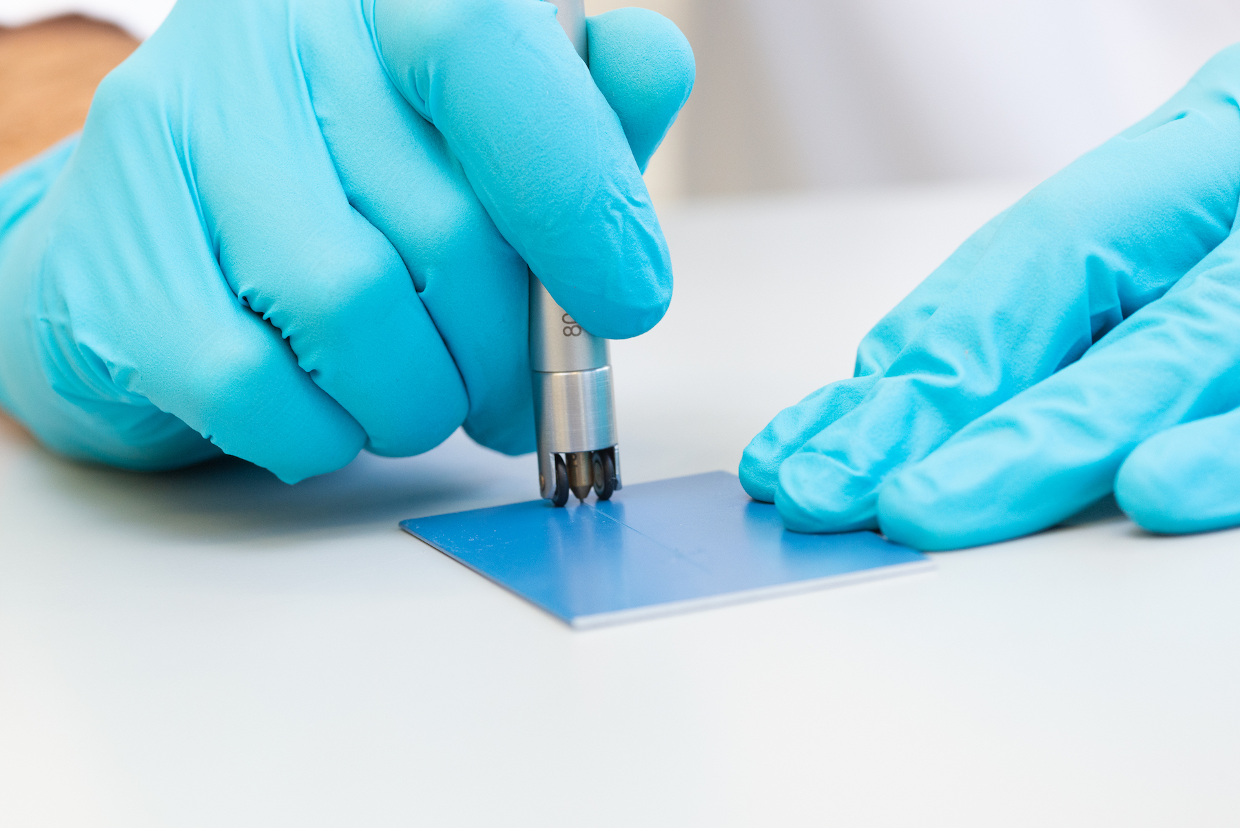 Scratch resistance test on a coated test panel