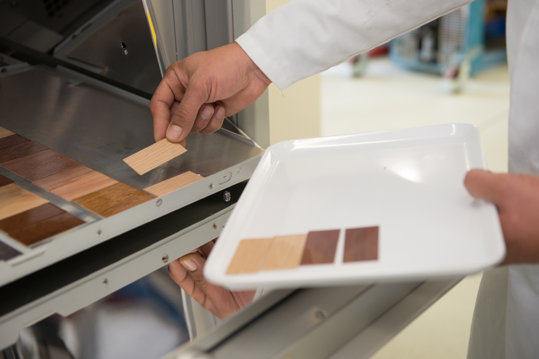 Wood-effect test specimens are removed from the weathering chamber